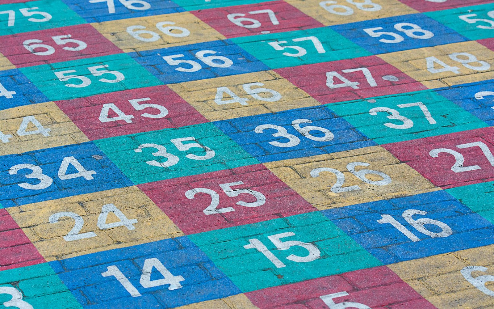 Colorful painted number grid on a playground pavement in blue, red, teal, and yellow squares