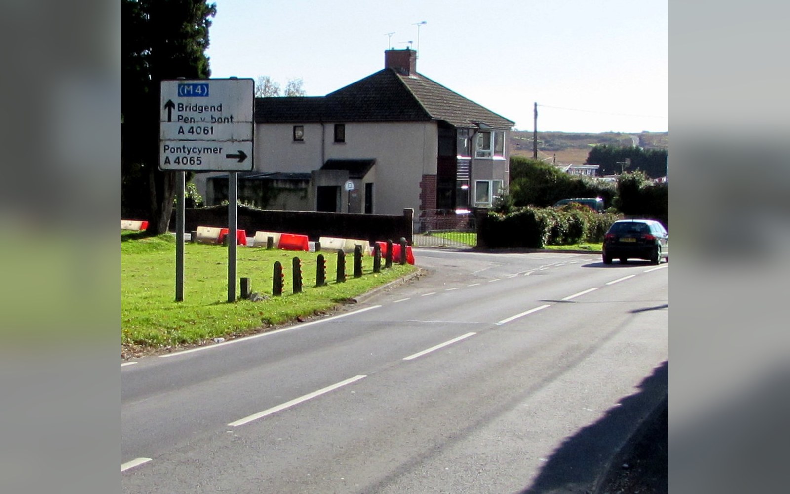 Road sign directing traffic to Bridgend, Pen-y-bont and Pontycymer along a rural road