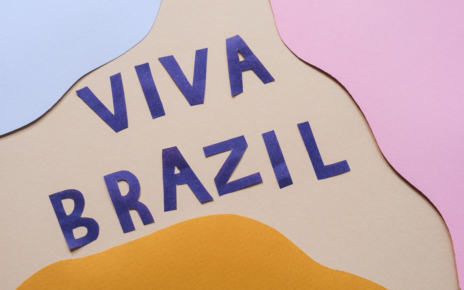 Cut-paper letters spelling "Viva Brazil" on layered tan, blue, pink and orange paper shapes