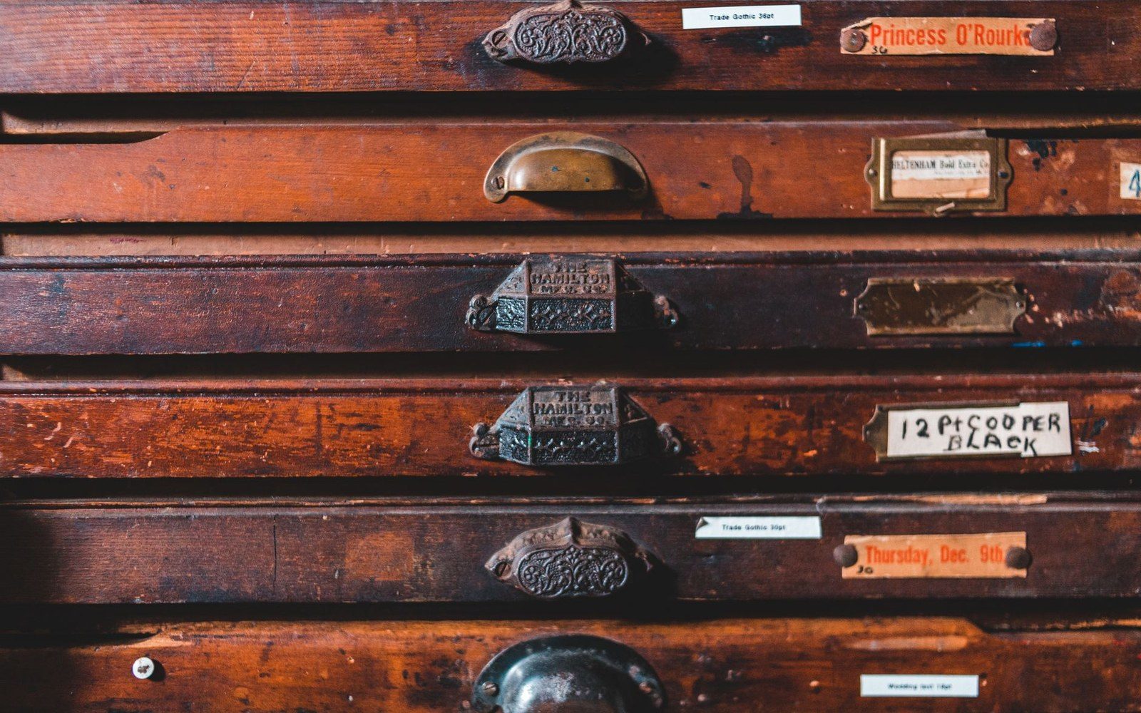 An open Hamilton wood-type drawer, viewed from above at a slight angle, showing capitals in a condensed Gothic face sorted by size